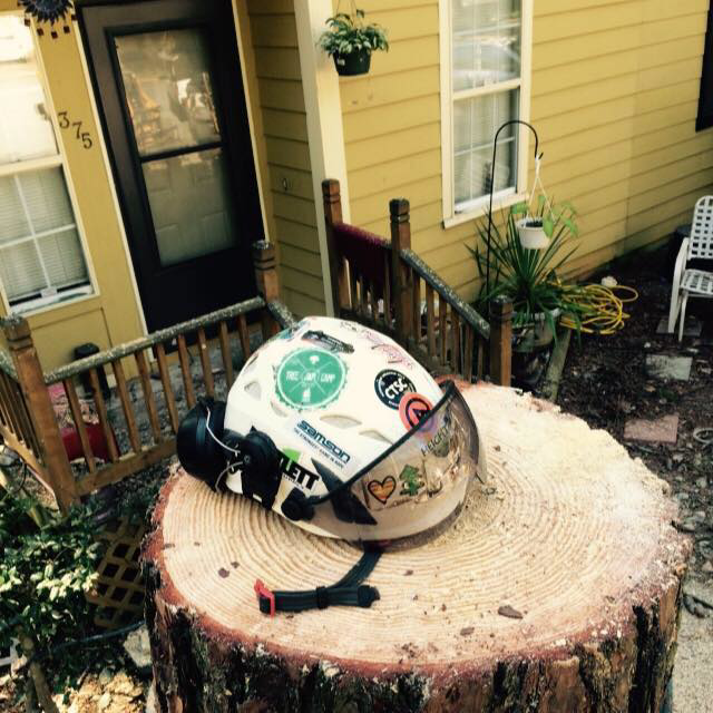 A safety helmet resting on a freshly cut tree stump after a job by Full Throttle Tree Service in Douglasville, GA