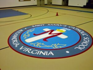 An indoor basketball court with the Saint Mary's Catholic School logo, installed by Abacus Sports Installations, Ltd in Lancaster, PA