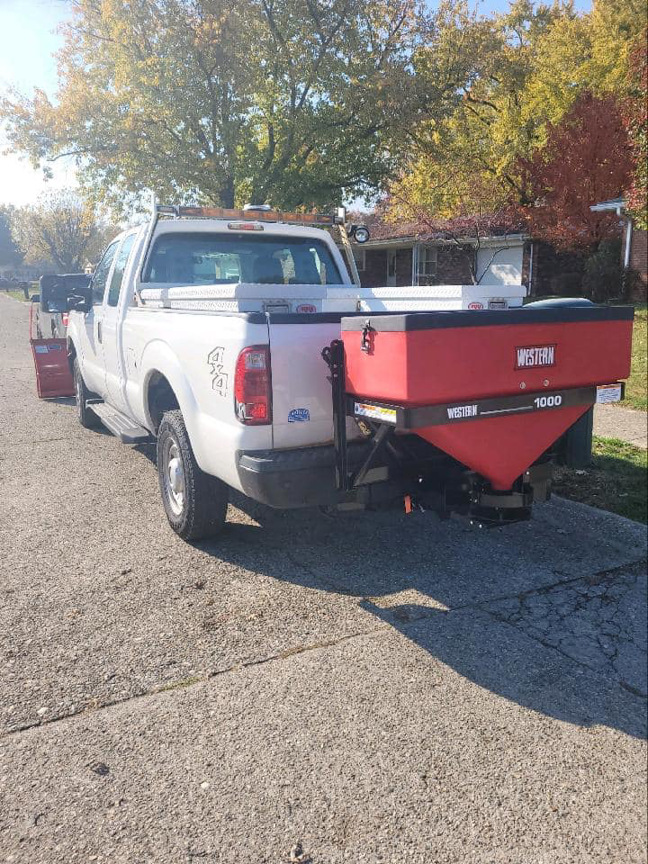 The rear of a white pickup truck with a red salt spreader attached, used by 24/7 Snow Removal & Salting for salting services in Indianapolis, IN.