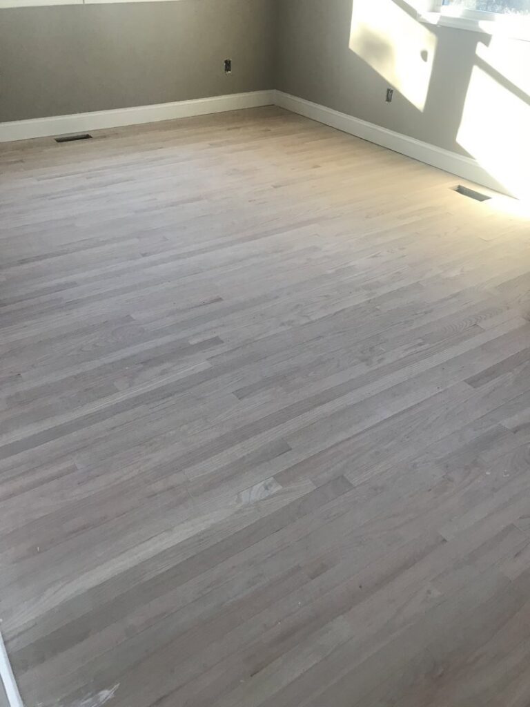 A newly sanded light-colored hardwood floor, prepared for finishing by Franco's Hardwood Flooring in Durham, NC.