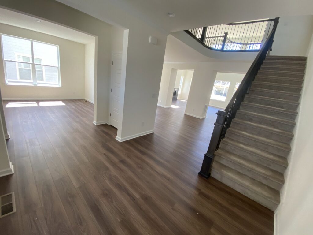 Stairs undergoing sanding and staining, with a sander tool visible, by IHS flooring LLC in Brighton, CO.