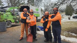 A Savatree crew stands with their truck and wood chipper in a snowy residential area in Burlington, VT.