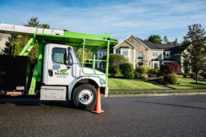 A Savatree truck with a bucket lift parked on a residential street for tree service in Burlington, VT.