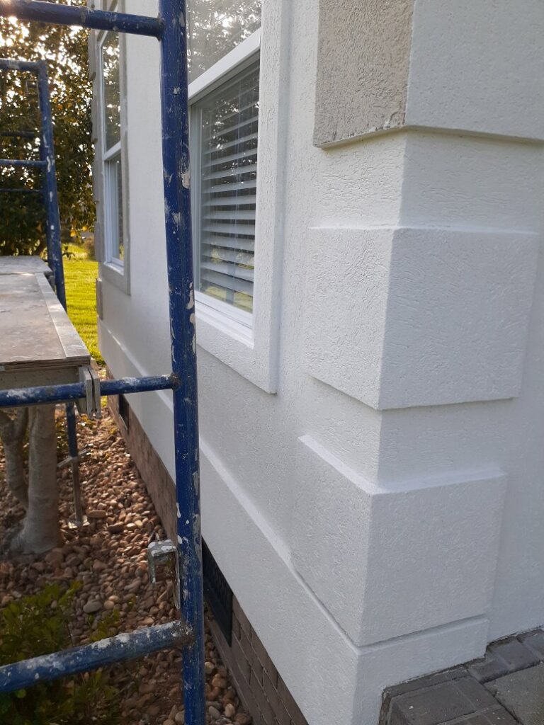 Scaffolding set up next to a newly finished stucco or EIFS wall on a building exterior by Modern Wall Systems in Virginia Beach, VA.