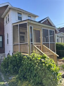 A newly constructed screened-in porch with wooden stairs and railings, built by McIntosh Construction in Des Peres, MO.