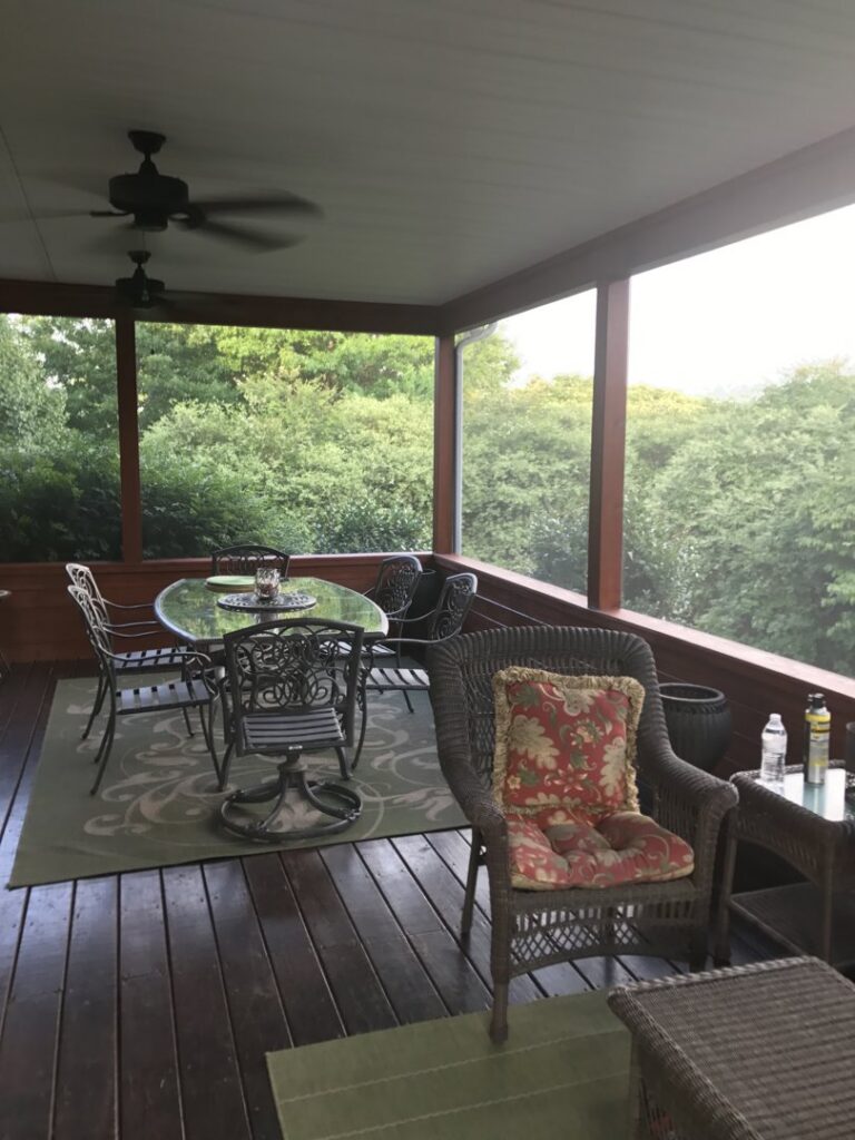 A comfortable screened-in porch with outdoor furniture, perfect for relaxation, built by Technically Aesthetic General Contractors in Johnson City, TN.