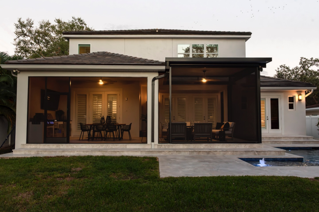 A beautifully designed screened patio with an outdoor kitchen and pool deck by Landscape-Fusion in Tampa, FL