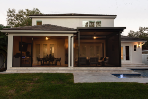A beautifully designed screened patio with an outdoor kitchen and pool deck by Landscape-Fusion in Tampa, FL