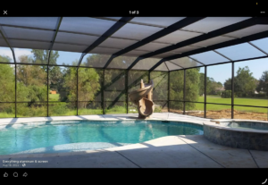 A spacious screened pool enclosure featuring a pool slide and hot tub, built by Cover Works in Luling, LA.