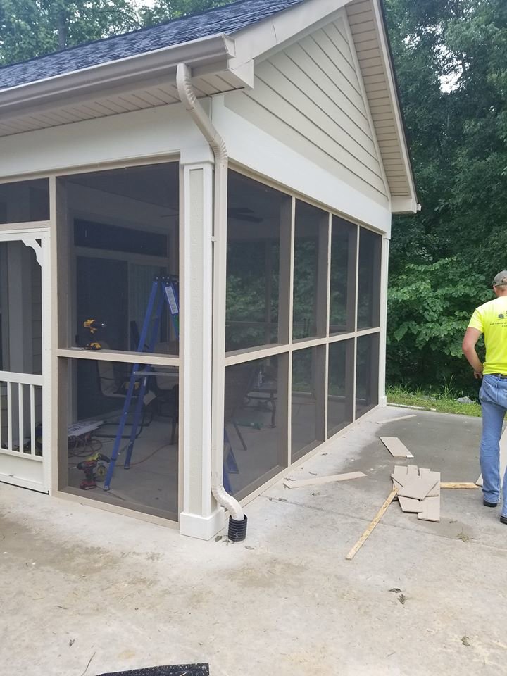 A screened porch under construction with tools and a worker by Dream Construction in Johnson City, TN.