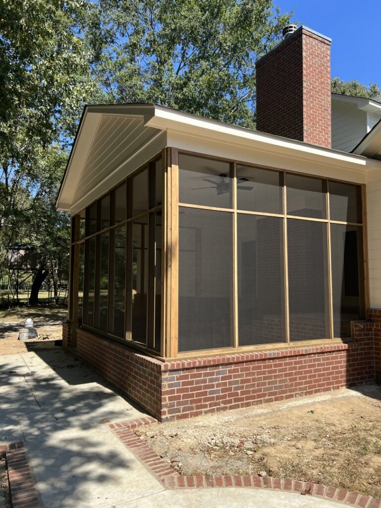 A newly constructed screened porch with a brick base and wooden framing by CMT Construction LLC in Columbia, MO.