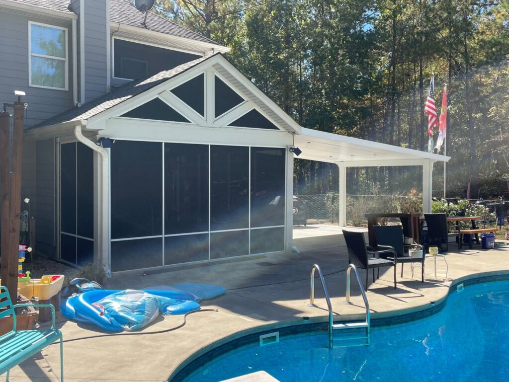 A screened-in porch and covered patio next to a swimming pool by Four Seasons of River City in Columbus, GA.