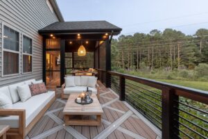A spacious outdoor deck with a screened-in porch and black metal railings by Constructive Design Group in Raleigh, NC