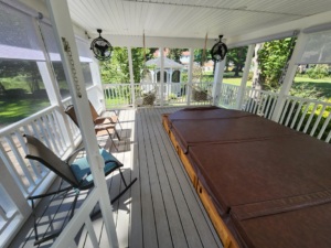 The interior of a newly built screened-in porch featuring a hot tub and ceiling fans by WHE Construction in Virginia Beach, VA