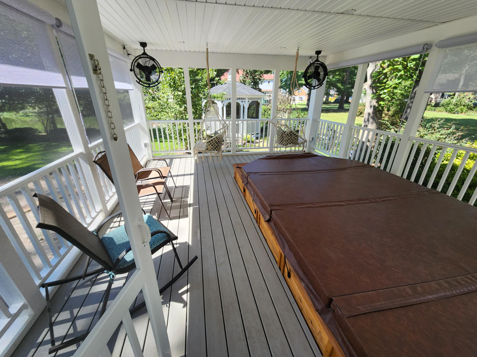 The interior of a newly built screened-in porch featuring a hot tub and ceiling fans by WHE Construction in Virginia Beach, VA