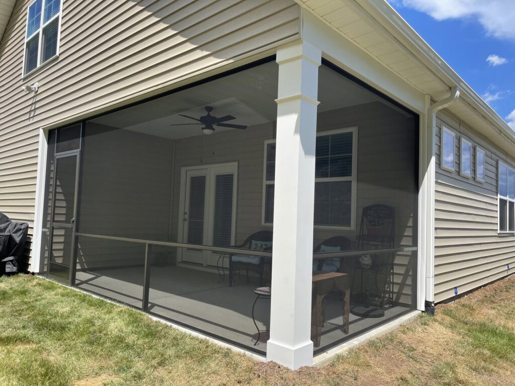 A comfortable screened porch with a ceiling fan for airflow, expertly completed by Screen Enc in Denver, NC