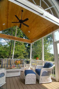An inviting screened porch with a wooden ceiling and ceiling fan by Rothrock Renovation & Remodeling in Winston-Salem, NC