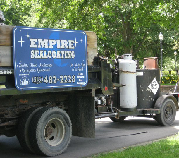 A work truck with sealcoating equipment and the Empire Sealcoating business sign in Albany, NY