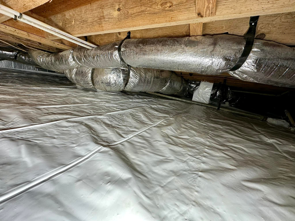 A sealed crawlspace showing protected ductwork and a clean vapor barrier by Ramos Waterproofing & Crawlspace Sealing LLC in Durham, NC.