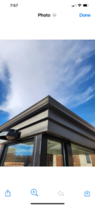 A newly installed seamless gutter system on the corner of a building by Dowlard Enterprises in Riverton, WY.