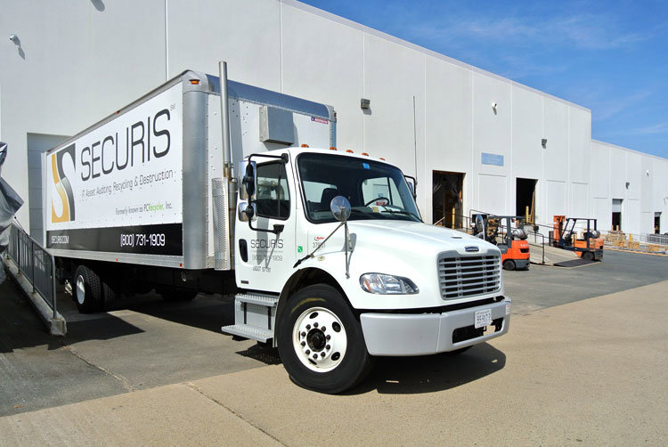 A Securis junk removal truck, branded for IT asset recycling and destruction, parked outside a warehouse in Greensboro, NC