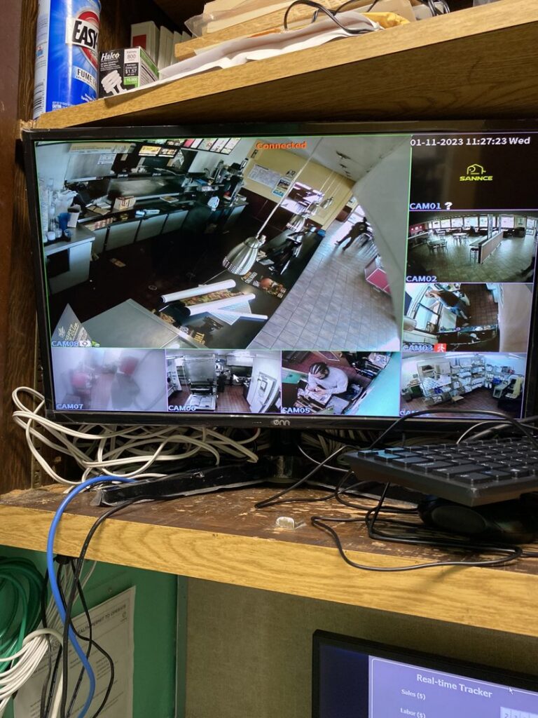 A monitor displaying multiple security camera feeds, indicating a system setup by Prospective 1, LLC in Sparks, NV.
