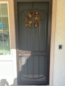 A front door with a newly installed security screen door and doorbell camera by Handyman Service's in North Las Vegas, NV.
