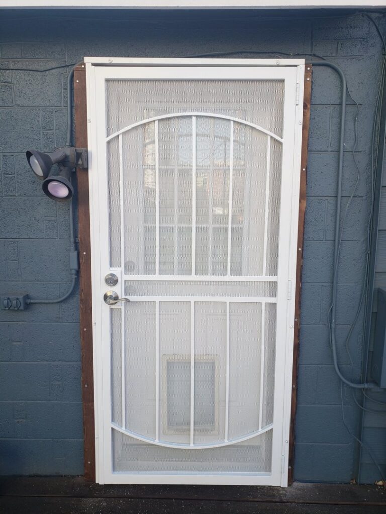 A newly installed white security screen door with a pet flap, a handyman service by Jesse Roofs Co. in Denver, CO