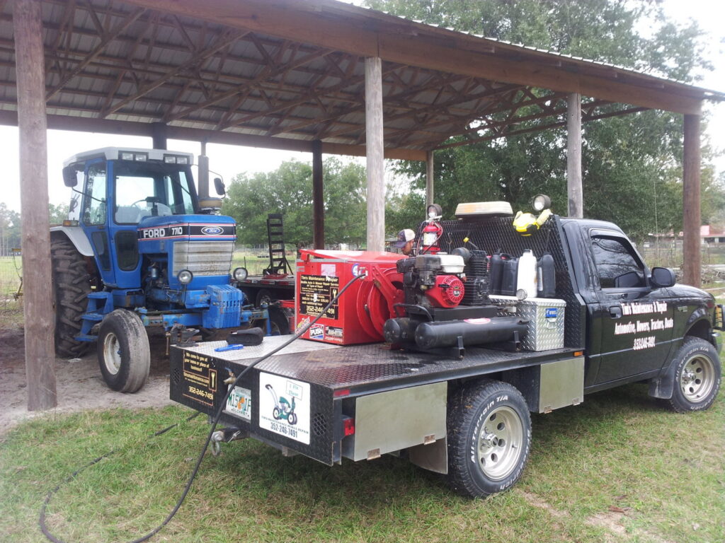 Tim's Maintenance & Repair service truck parked next to a blue tractor, ready for repair work in Las Vegas, NV
