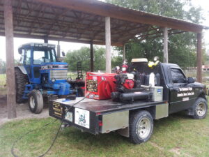 Tim's Maintenance & Repair service truck parked next to a blue tractor, ready for repair work in Las Vegas, NV