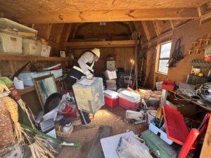 A worker performing a shed cleanout, removing various items as part of a junk removal service by City to City Junk Removal Fort Worth, TX.
