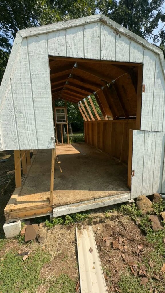 A partially demolished shed ready for complete removal by Strong Lion Junk Removal in Fayetteville, AR.