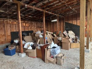 A shed or garage interior filled with a large accumulation of boxes and miscellaneous junk, ready for removal by Missoula Junk Removal, LLC in Missoula, MT.
