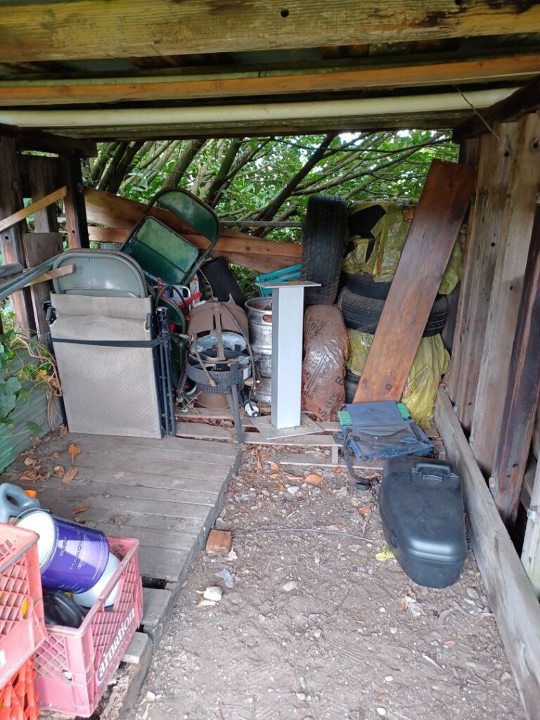 A shed packed with old furniture, tires, a grill, and various junk items, ready for cleanout by Down and Dirty Junk Removal in Tacoma, WA.