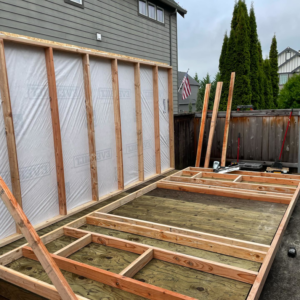 A shed frame under construction with walls partially built, showing handyman work by Shed Crafters in Sycamore, IL.