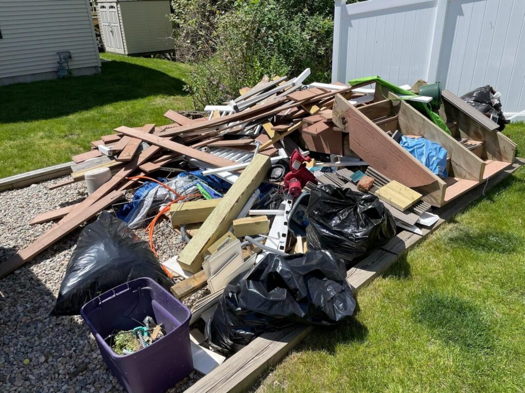 A shed filled with wood and debris, indicating a cleanout or demolition job by CK Junk Removal in New Bedford, MA