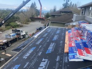 Bundles of new shingles being delivered by crane for a roof replacement by Sunny's roofing LLC in Denver, CO.