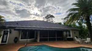 A house with a dark shingle roof and a black awning over a patio area, representing a completed project by Hastings Roofing Service Inc. in Orlando, FL.