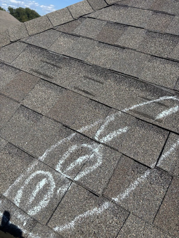 Shingle roof with chalk marks indicating areas for repair by Hansen Construction Stillwater in Stillwater, OK.