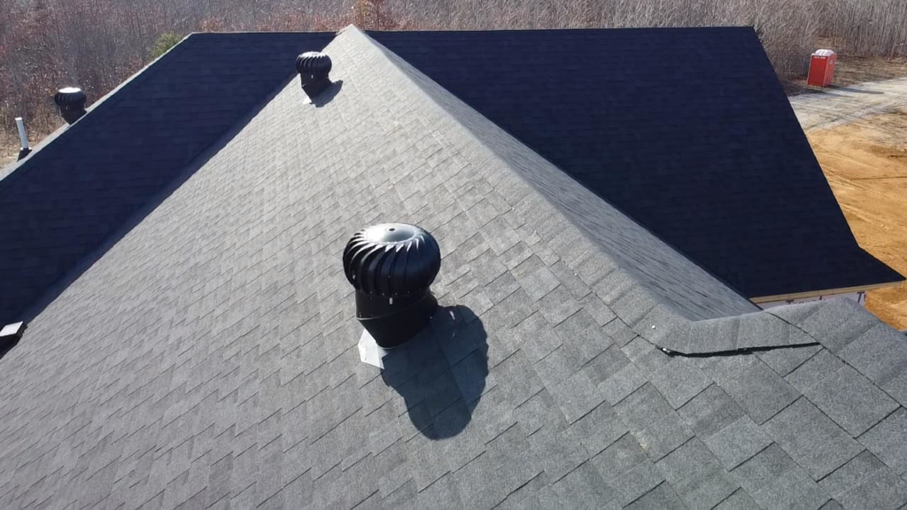 An aerial view of a shingle roof featuring two installed turbine vents by SJL Contracting, LLC in Owensboro, KY.