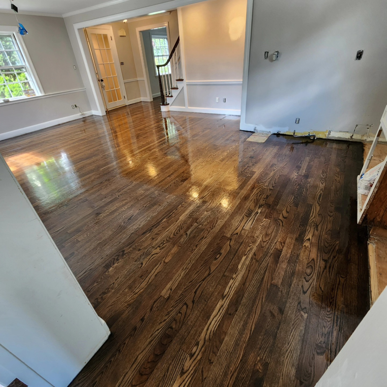 A shiny dark hardwood floor in a recently renovated room, expertly installed by floorzone.inc in Los Angeles, CA.