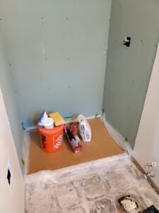 A shower area with new green board drywall installed, ready for tiling, part of a bathroom renovation by Homefix Lawrence in Lawrence, KS.