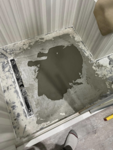 Fresh mortar applied to a shower floor during a renovation project by Form Fluent in Kodiak, AK.