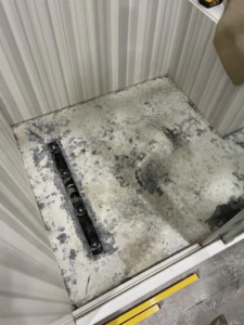 Shower floor prepared for new tiling, showing old adhesive residue, a service provided by Form Fluent in Kodiak, AK.