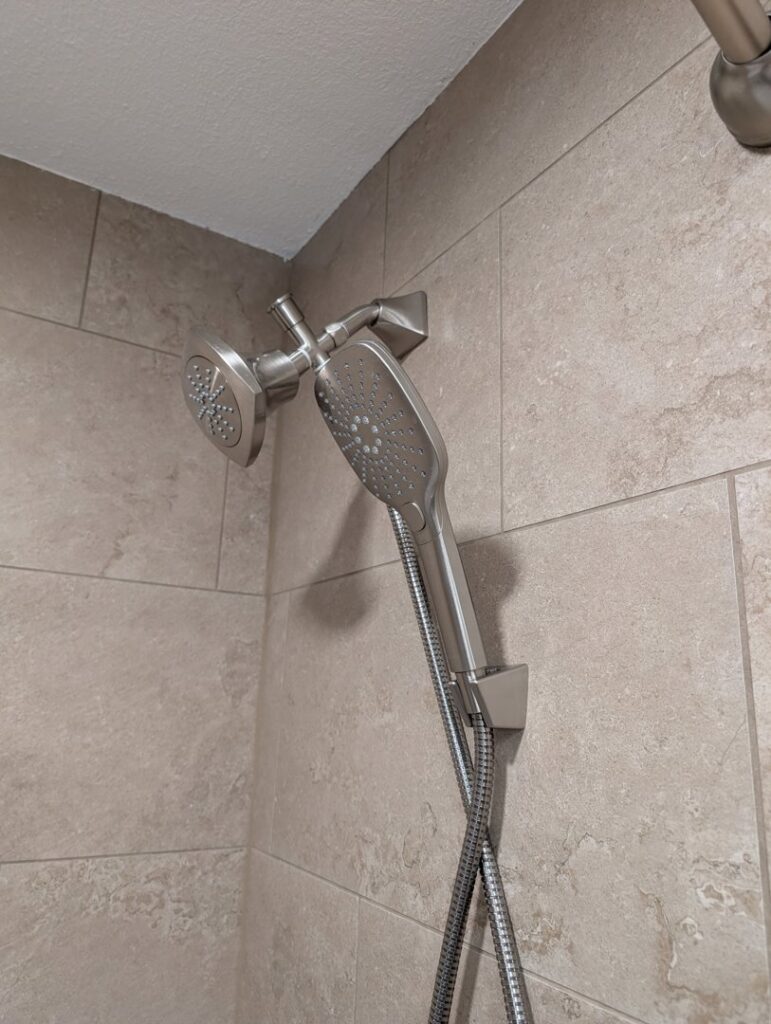 A modern shower head and handheld sprayer fixture professionally installed by H4 Construction and Remodeling in Blue Springs, MO.