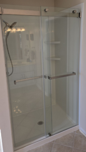 A clean shower enclosure with sliding glass doors and a bright white interior by The Shower Company in Kansas City, MO.