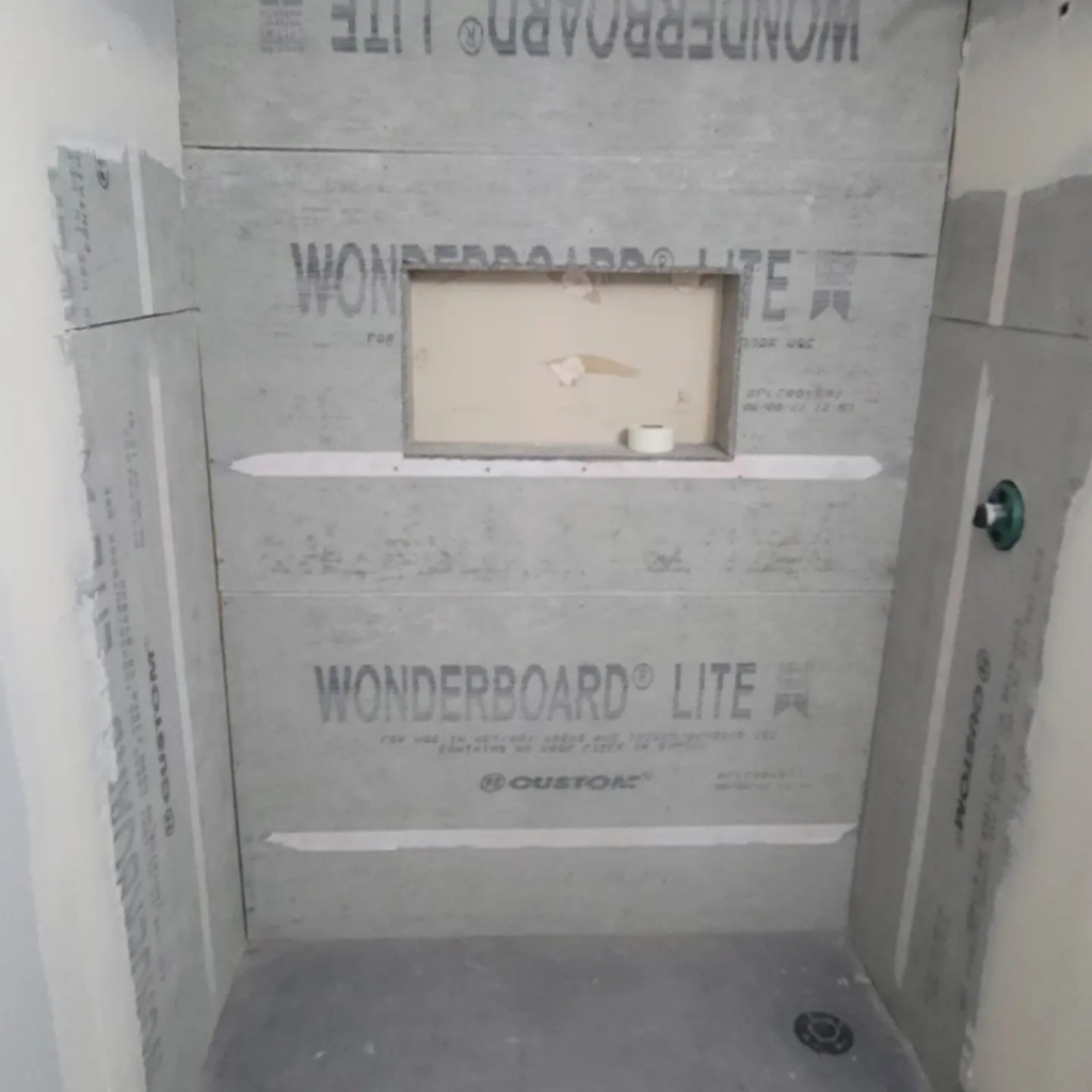 A shower stall with Wonderboard Lite cement board installed, ready for tiling by Tier 1 Contracting Inc. in Apache Junction, AZ.