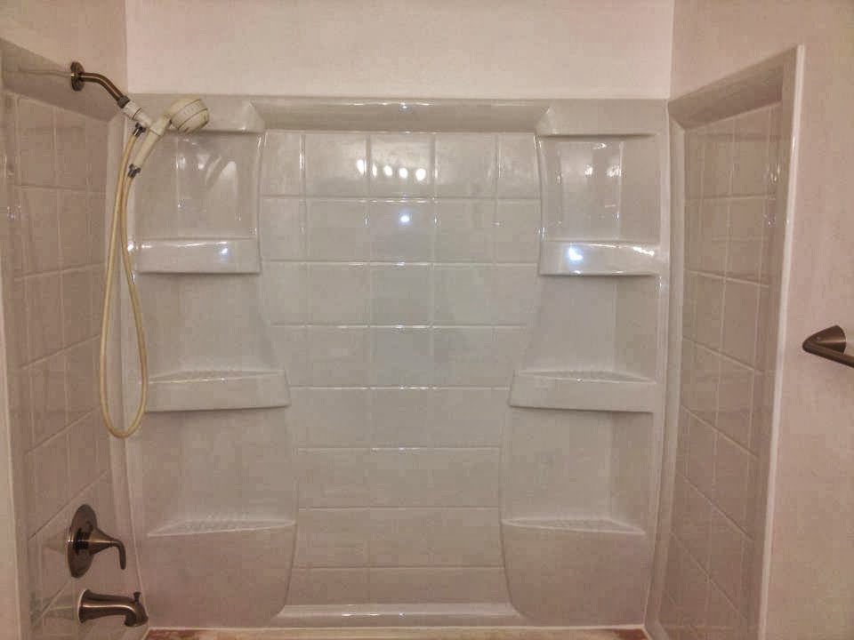 A clean white shower stall with built-in shelving, installed by Ground Up Services in Anchorage, AK.