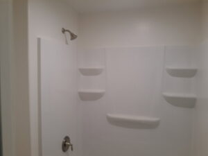A newly installed shower stall with built-in shelving and modern fixtures by Eagle Rock Handyman Services in Caldwell, ID.