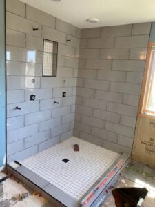 Shower tile installation in progress, showing wall tiles and a shower pan grid by CSR Tile Construction LLC in Minneapolis, MN.